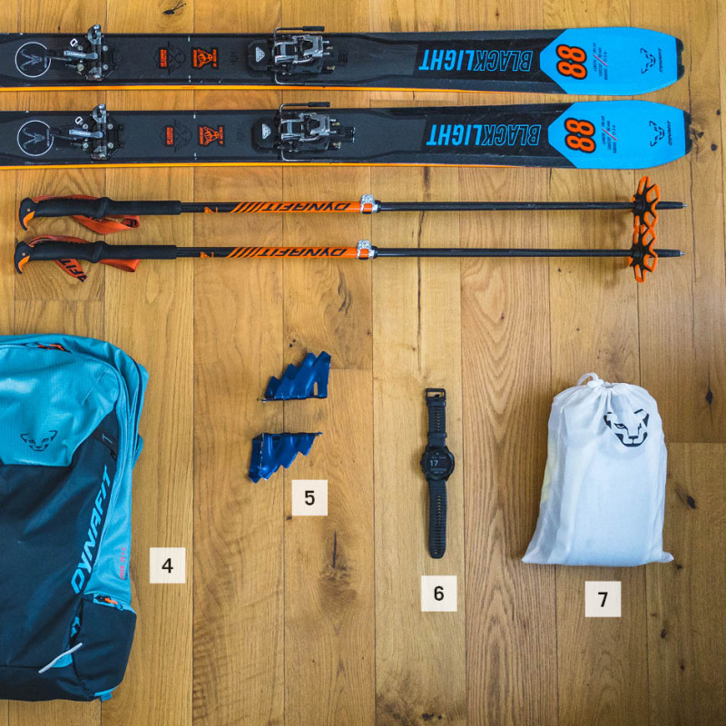 Top: Skis and ski poles below them; bottom from left to right: boots, backpack, ski crampons, GPS watch, skins.